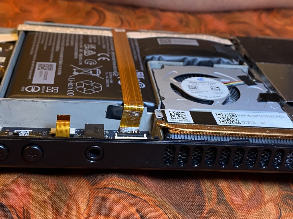 View of the battery on the inside of an LCD model Steam Deck. This view is from the top side of the device, looking down on the battery. You can see that the bottom of the battery L is visibly puffy.